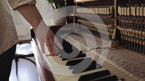 Woman touch keyboard of vintage wooden piano