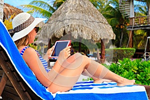 Woman with touch pad on tropical vacation