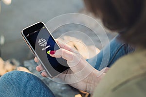 Woman touch the screen of her smartphone showing roaming