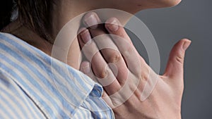 Woman touches her throat her hand and swallows. Sore throat, tonsillitis, laryngitis, pharyngitis, enterovirus infection