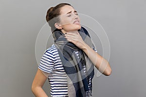 Woman touches neck, suffers from sore throat, cant breath well, chokes and smirks face.