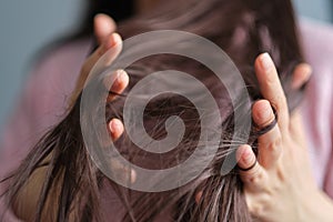 woman touches tangled dry hair. hair care in winter. Long Disheveled Hair, Holding Messy Hair