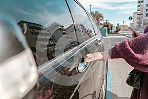 Woman touching the automotive exterior door handle