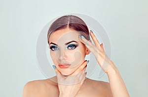 Woman touching face with hands showing perfect makeup and soft skin