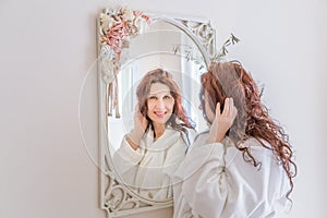 Woman touching hair in mirror