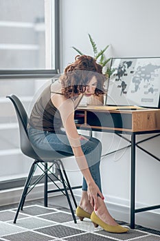 Woman touching her aching feet in a new shoe