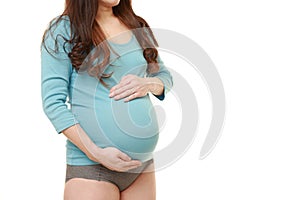 Woman touching her growing pregnant belly