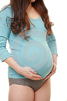 Woman touching her growing pregnant belly