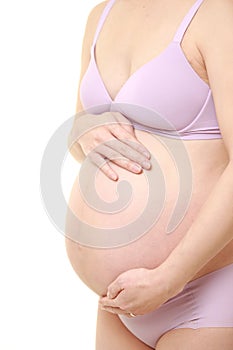 Woman touching her growing pregnant belly
