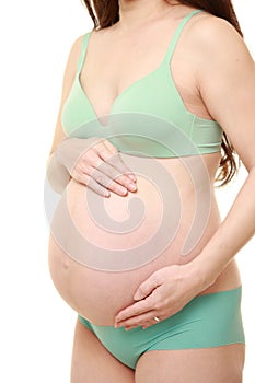 Woman touching her growing pregnant belly