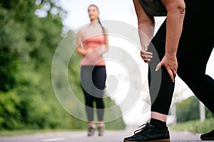 Woman touching her knee, sports injury at jogging