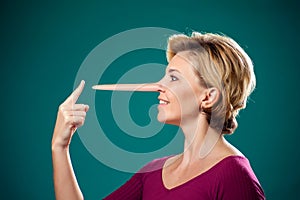 Woman touching her long nose because of lie . People,lifestyle and emotions concept