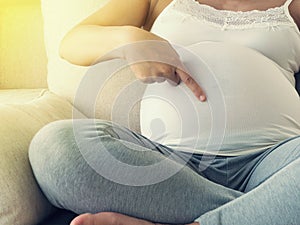 Woman touching her pregnant tummy.