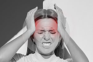 Woman touching her temples, having strong headache. Cluster headache, migraine