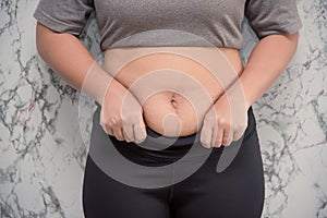 woman touching his belly on white background , fat