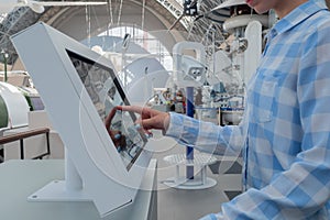 Woman touching interactive touchscreen display kiosk at exhibition: close up