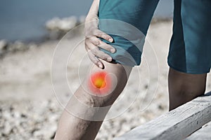 Woman touching painful varicose veins on a leg with red dot effect