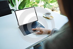 A woman touching on tablet touchpad with blank white desktop screen as computer pc in the office