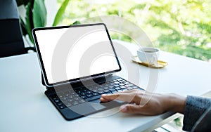 A woman touching on tablet touchpad with blank white desktop screen as computer pc in the office