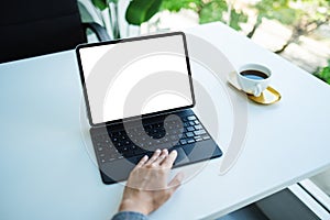 A woman touching on tablet touchpad with blank white desktop screen as computer pc in the office