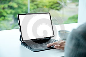 A woman touching on tablet touchpad with blank white desktop screen as computer pc in the office