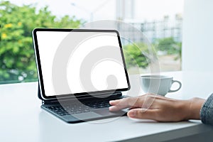 A woman touching on tablet touchpad with blank white desktop screen as computer pc in the office