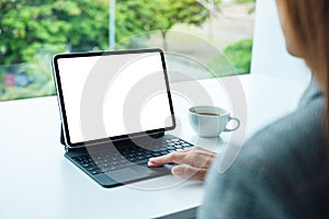 A woman touching on tablet touchpad with blank white desktop screen as computer pc in the office