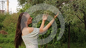 Woman touching tree branches in garden