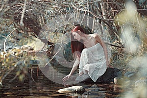 Woman touching water in a stream