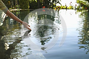 Woman Touching Water Of Swimming Pool