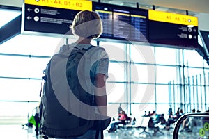 Woman tourist in airport terminal waiting for flight and looking