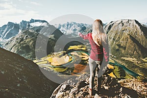 Woman tourist alone standing on cliff aerial mountains