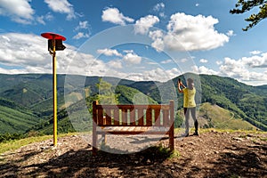 Žena a turistická atrakce lavička na vrcholu kopce Čipcie na Slovensku