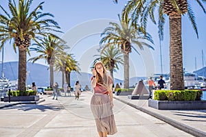 Woman tourist on background of Yacht marina, beautiful Mediterranean landscape in warm colors. Montenegro, Kotor Bay