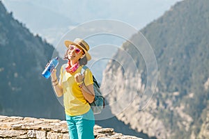 Woman tourist with backpack drinking water from bottle