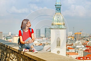 Turistka s batohom a slnečnými okuliarmi odpočíva na vyhliadke do Bratislavy