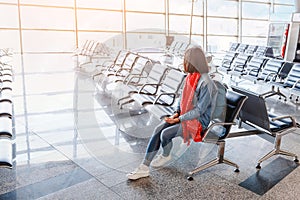 Woman tourist with a backpack waiting for flight in the airport lounge room