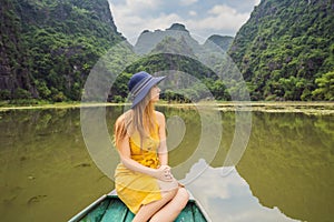 Woman tourist in boat on the lake Tam Coc, Ninh Binh, Viet nam. It& x27;s is UNESCO World Heritage Site, renowned for its