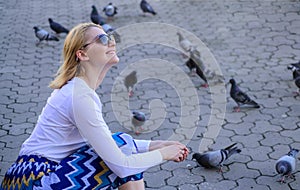 Woman tourist or citizen toss crumbs for pigeons. Girl feeding dove birds. Group doves on city square waiting treats