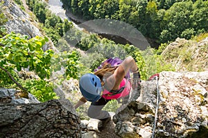 Woman tourist climbing a via ferrata route in Vadu Crisului, Apuseni mountains, Romania