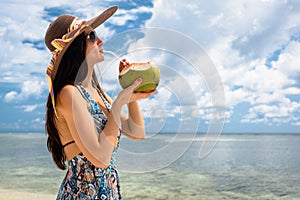 Woman tourist drinking coconut milk at beach in holidays