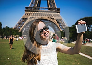 Woman tourist at Eiffel Tower smiling and making