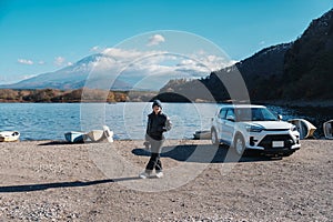 Woman tourist enjoy with Fuji Mountain at Lake Shoji, happy Traveler sightseeing Mount Fuji and road trip Fuji Five Lakes.