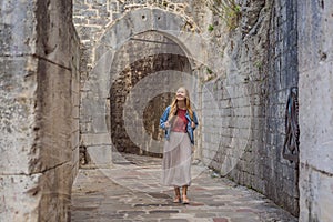 Woman tourist enjoying Colorful street in Old town of Kotor on a sunny day, Montenegro. Travel to Montenegro concept