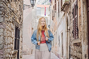 Woman tourist enjoying Colorful street in Old town of Kotor on a sunny day, Montenegro. Travel to Montenegro concept