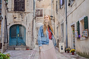 Woman tourist enjoying Colorful street in Old town of Kotor on a sunny day, Montenegro. Travel to Montenegro concept