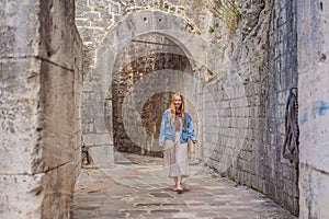 Woman tourist enjoying Colorful street in Old town of Kotor on a sunny day, Montenegro. Travel to Montenegro concept