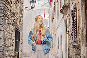 Woman tourist enjoying Colorful street in Old town of Kotor on a sunny day, Montenegro. Travel to Montenegro concept