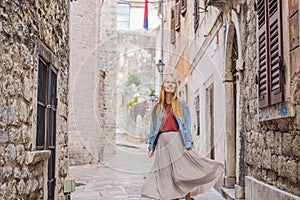 Woman tourist enjoying Colorful street in Old town of Kotor on a sunny day, Montenegro. Travel to Montenegro concept
