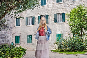 Woman tourist enjoying Colorful street in Old town of Kotor on a sunny day, Montenegro. Travel to Montenegro concept